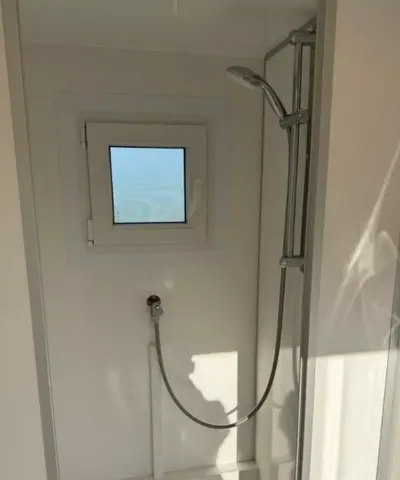 EW420 4P, douche met handdouche aan een glijstang onder een raam