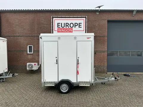 Dubbele mobiele badkamer, witte wagen met twee gesloten deuren aan de voorzijde