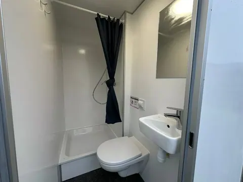 Dubbele mobiele badkamer, tweede badkamerruimte met douchebak, wastafel en wandtoilet