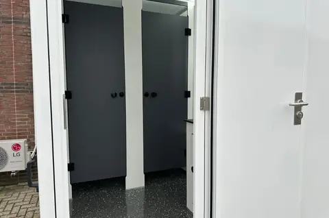 GL3200 1A212, ingang met twee gesloten donkergrijze deuren en een glanzende zwarte vloer