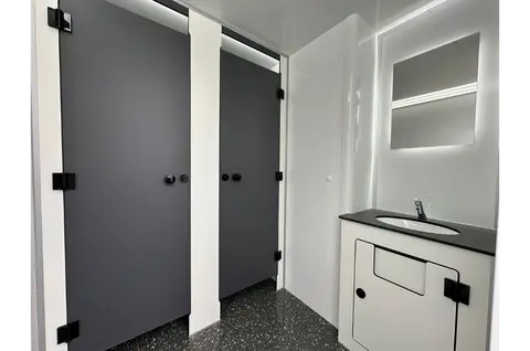 GL4200 212, twee gesloten toiletcabines en een wastafel met spiegel