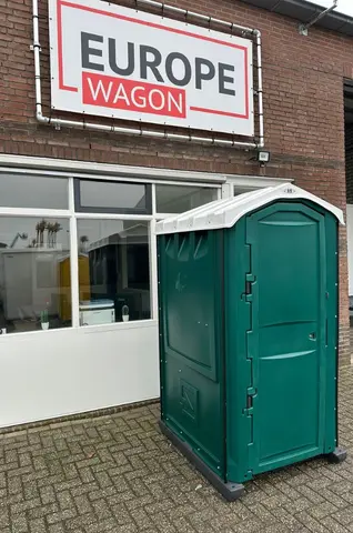 MTM donkergroen, mobiele toiletunit buiten bij een bedrijfspand