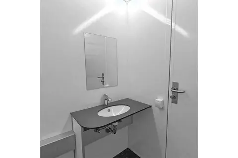 GM C2800 Handicap Douche, kleine badkamer met een wastafel, spiegel en deur in een witte ruimte