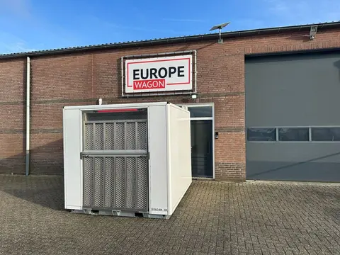 MIVA-toiletcontainer, buiten een loods met de oprijplaat vooraan