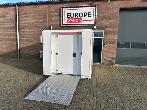 MIVA-toiletcontainer, open deur en uitgeklapte oprijplaat op een plein