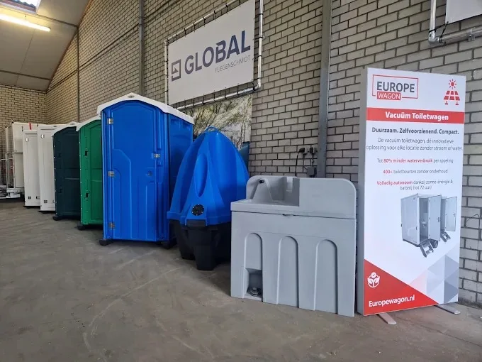 Toiletcabines in groen, blauw en wit en een grijze handwasunit voor een muur met het Global-logo